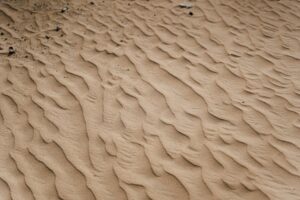 A close-up view of textured sand dunes in a tranquil desert environment.