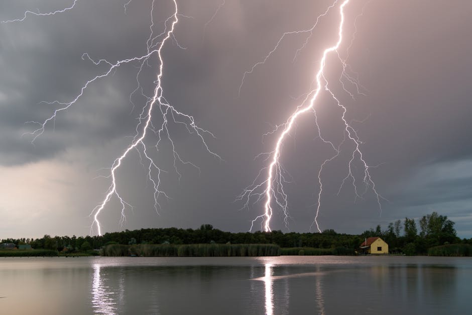 Stunning capture of multiple lightning bolts striking over a calm lake during a thunderstorm at twilight.