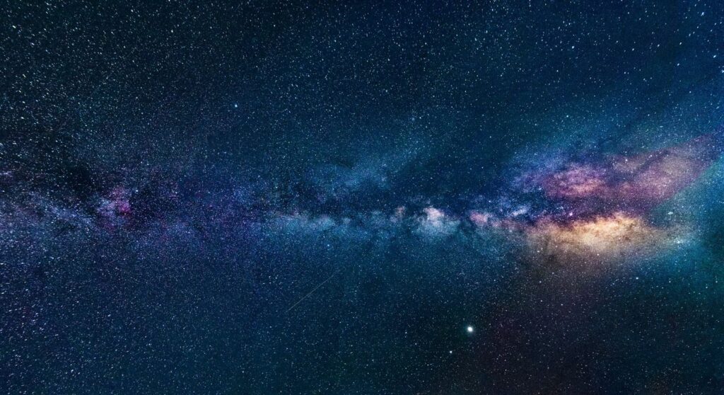 Capture of the Milky Way galaxy stretching across the dark night sky, filled with stars.